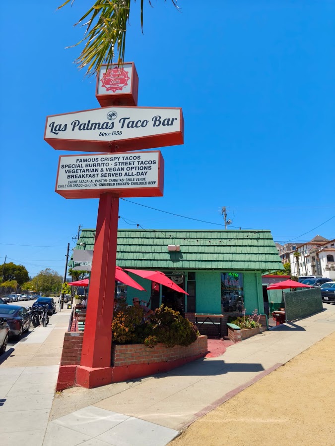 The Las Palmas Taco Bar sign, green-roofed taco bar and red patio umbrellas at 55 Front Street, Santa Cruz